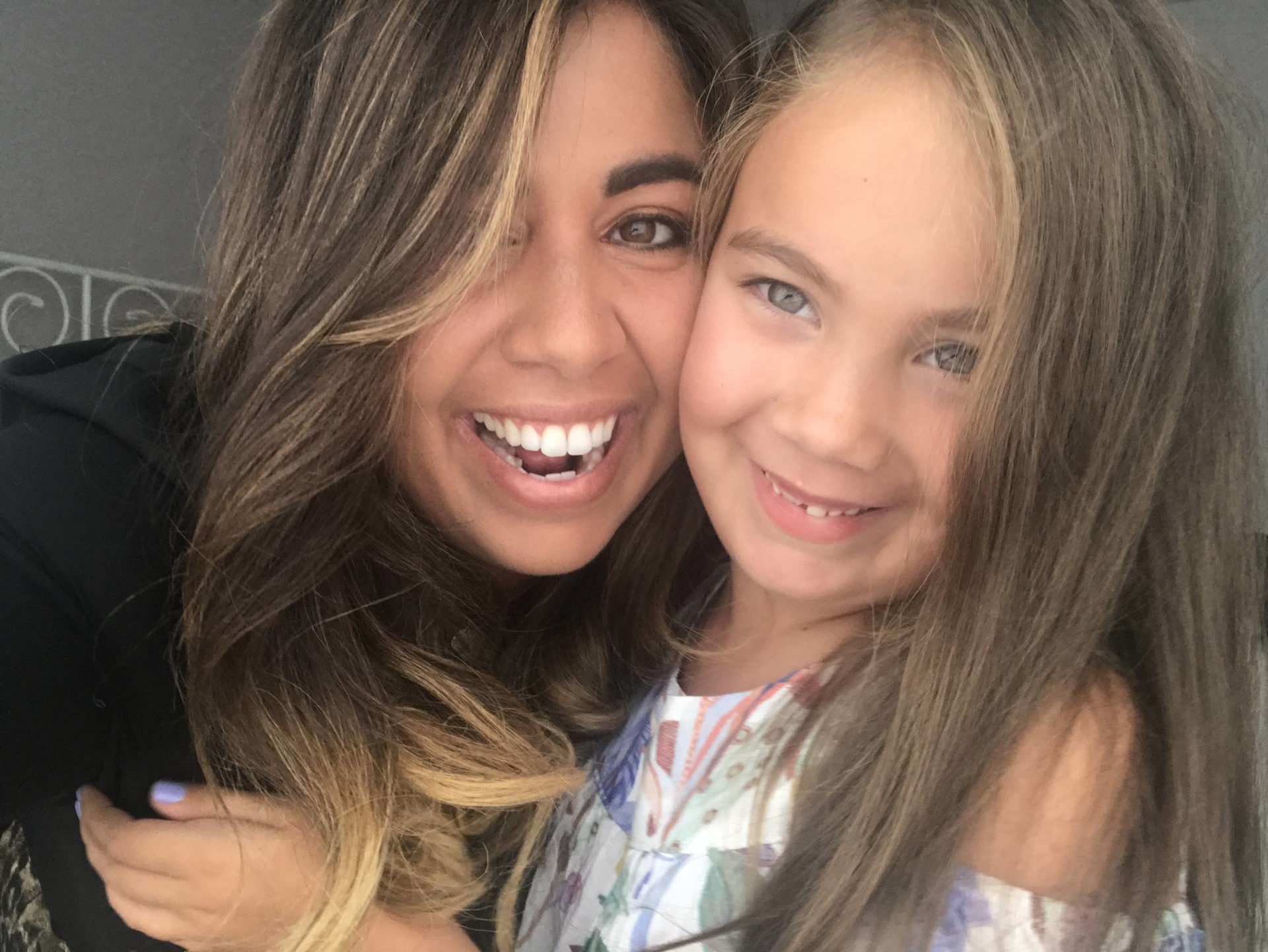 Selfie style photo of a mother a daughter smiling and hugging