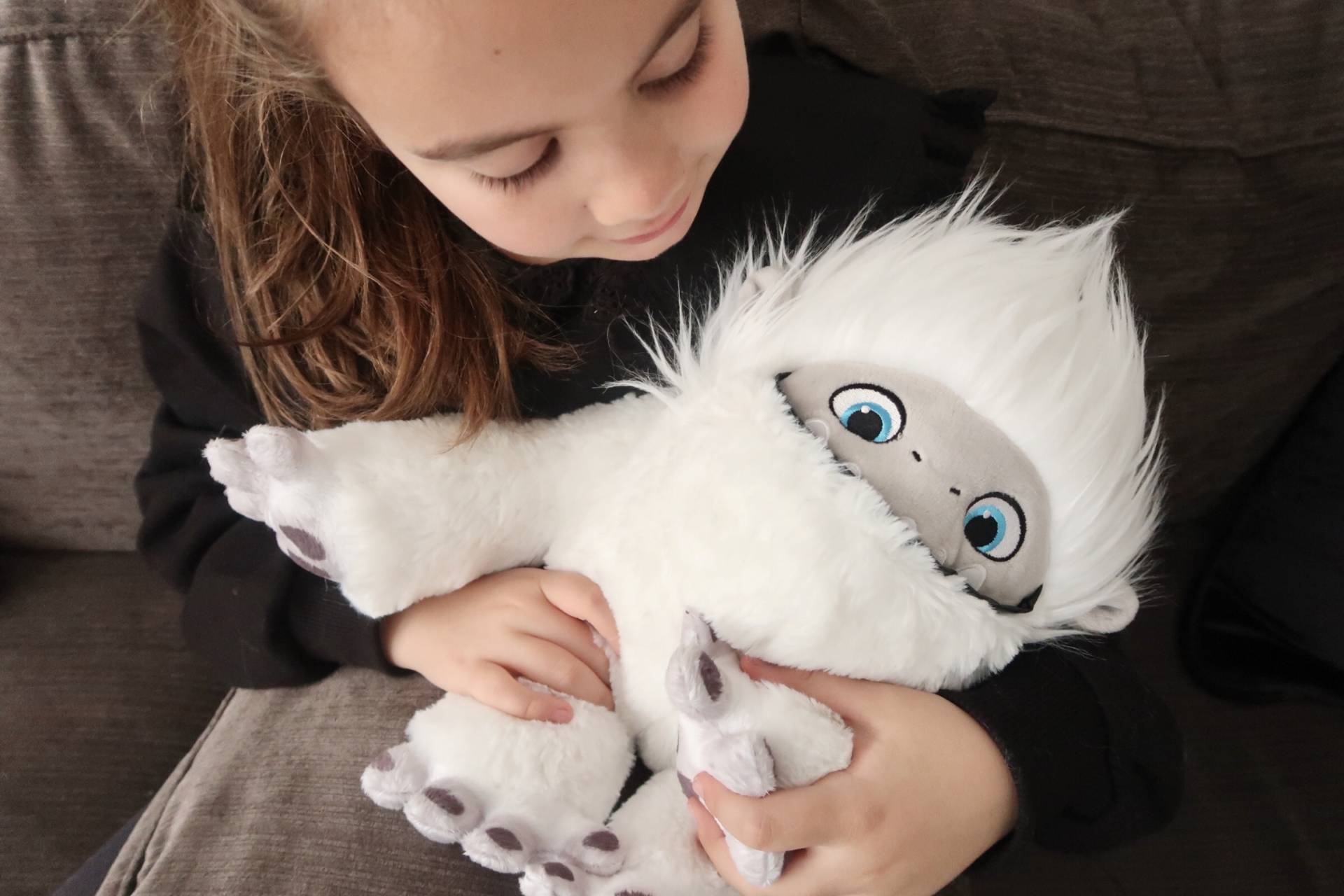 child cuddling fluffy yeti toy