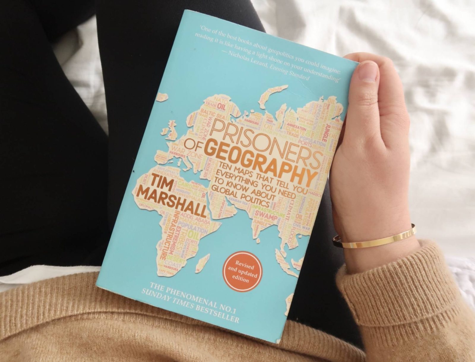 Woman sat on bed holding book