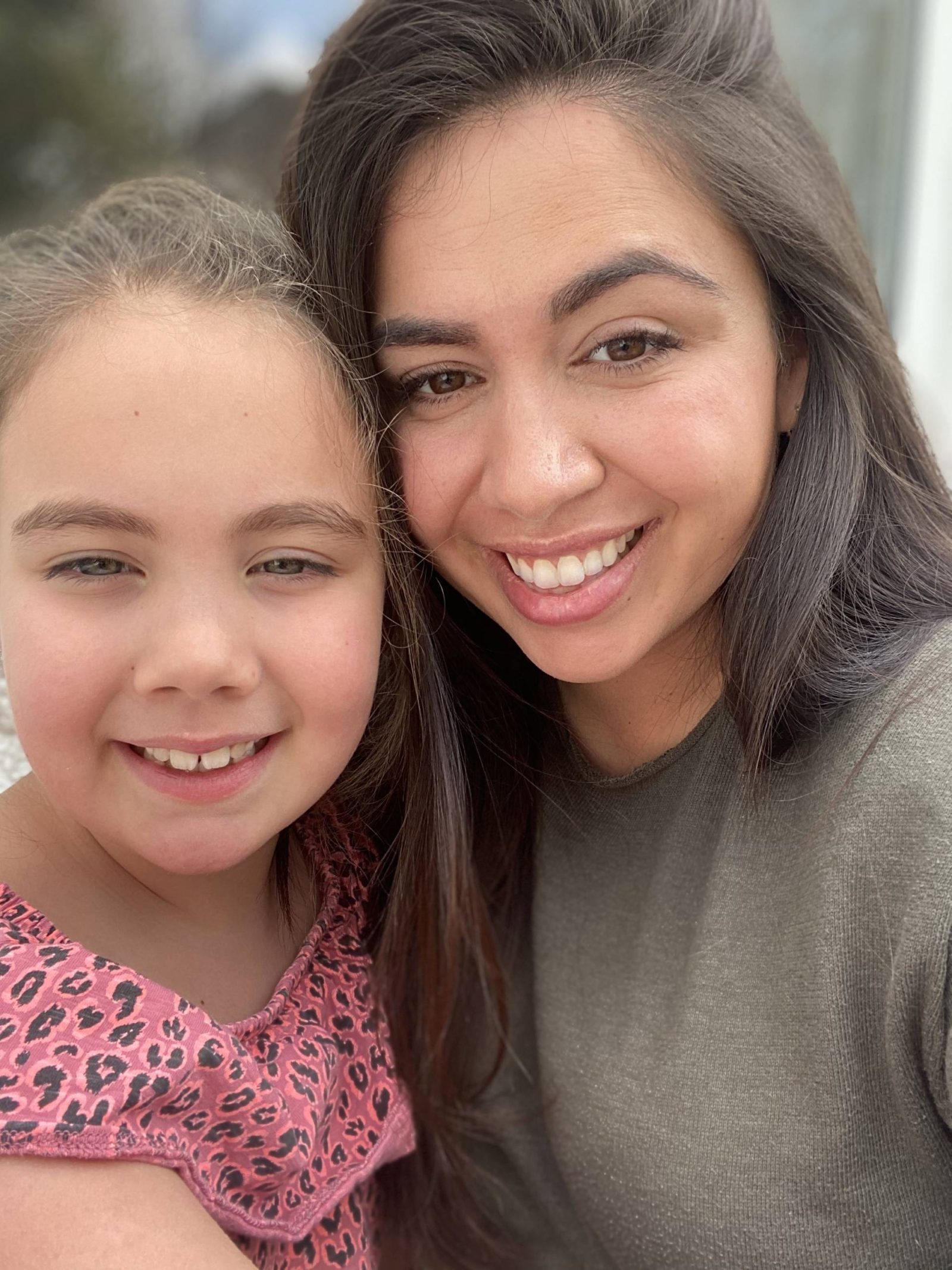 Photo of mother and daughter smiling with heads together 