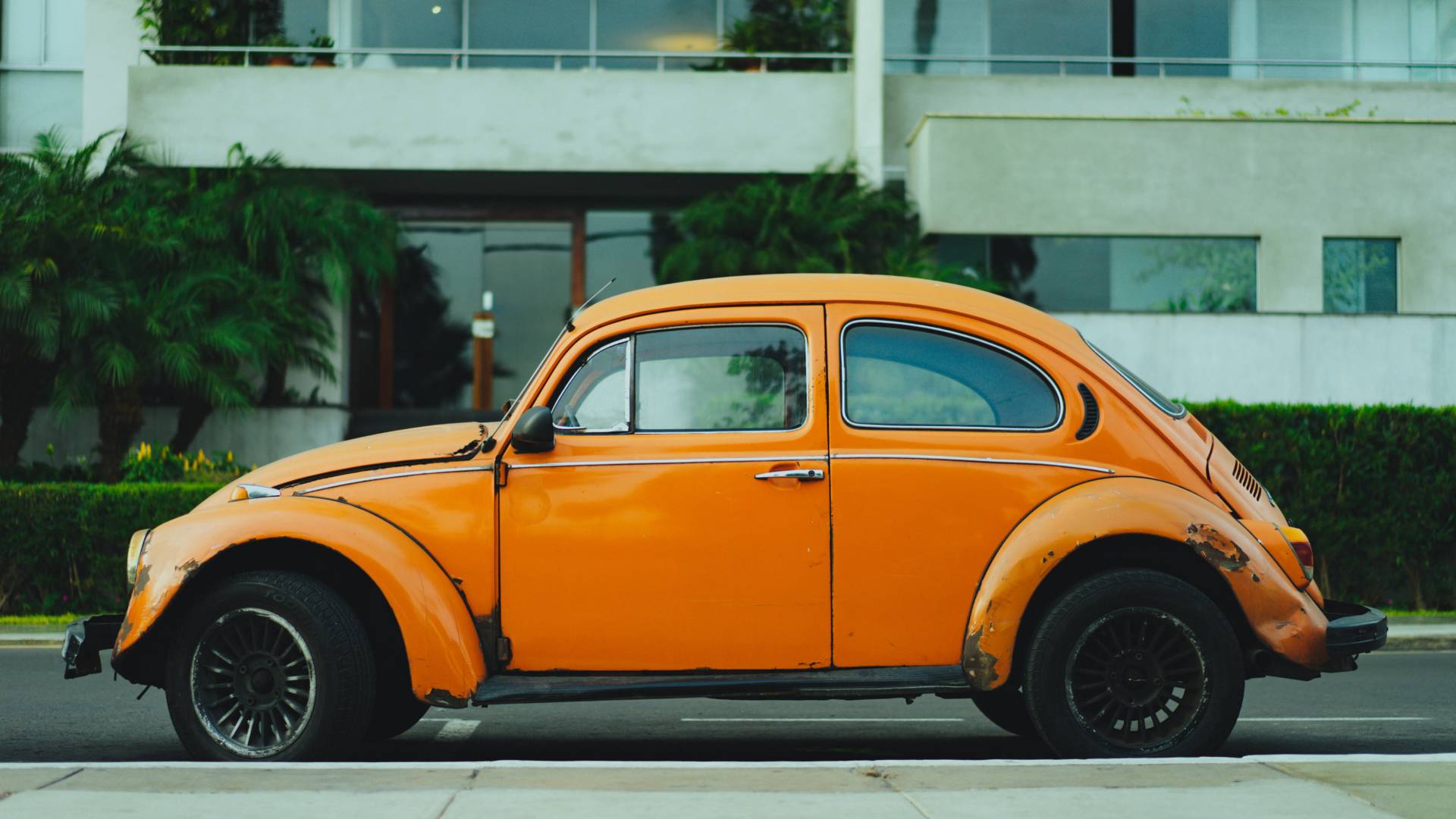 yellow VW beetle car outside white building