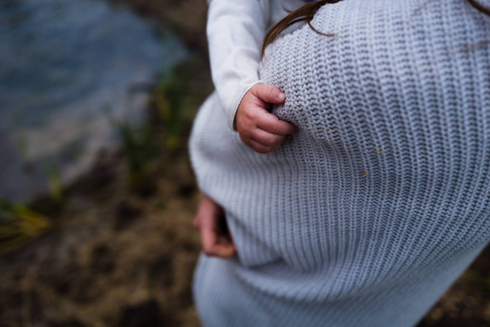 woman holding baby - close up of baby's hand and foot - outside setting