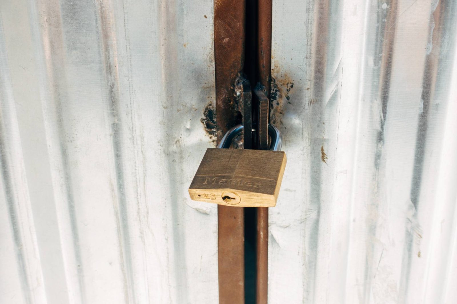 White corrugated doors secured with brass padlock