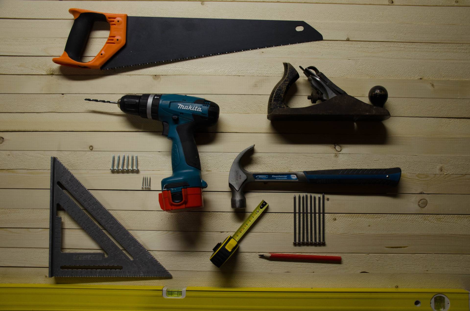 Collection of DIY tools laid flat on light wooden background