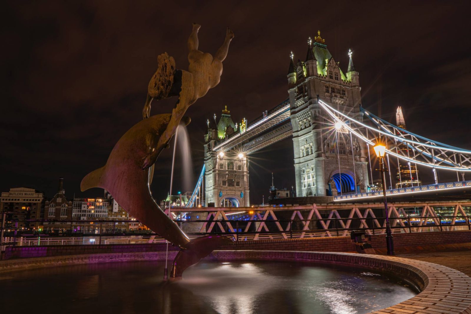 Tower Bridge light up at night with a fountain in front