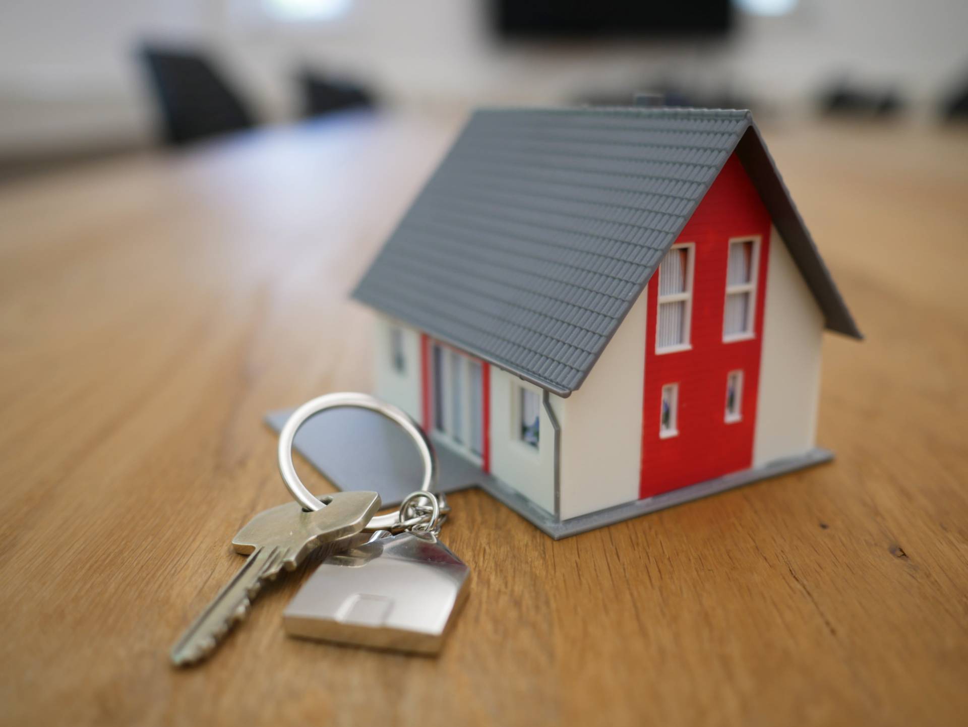 miniature toy house next to set of keys on table