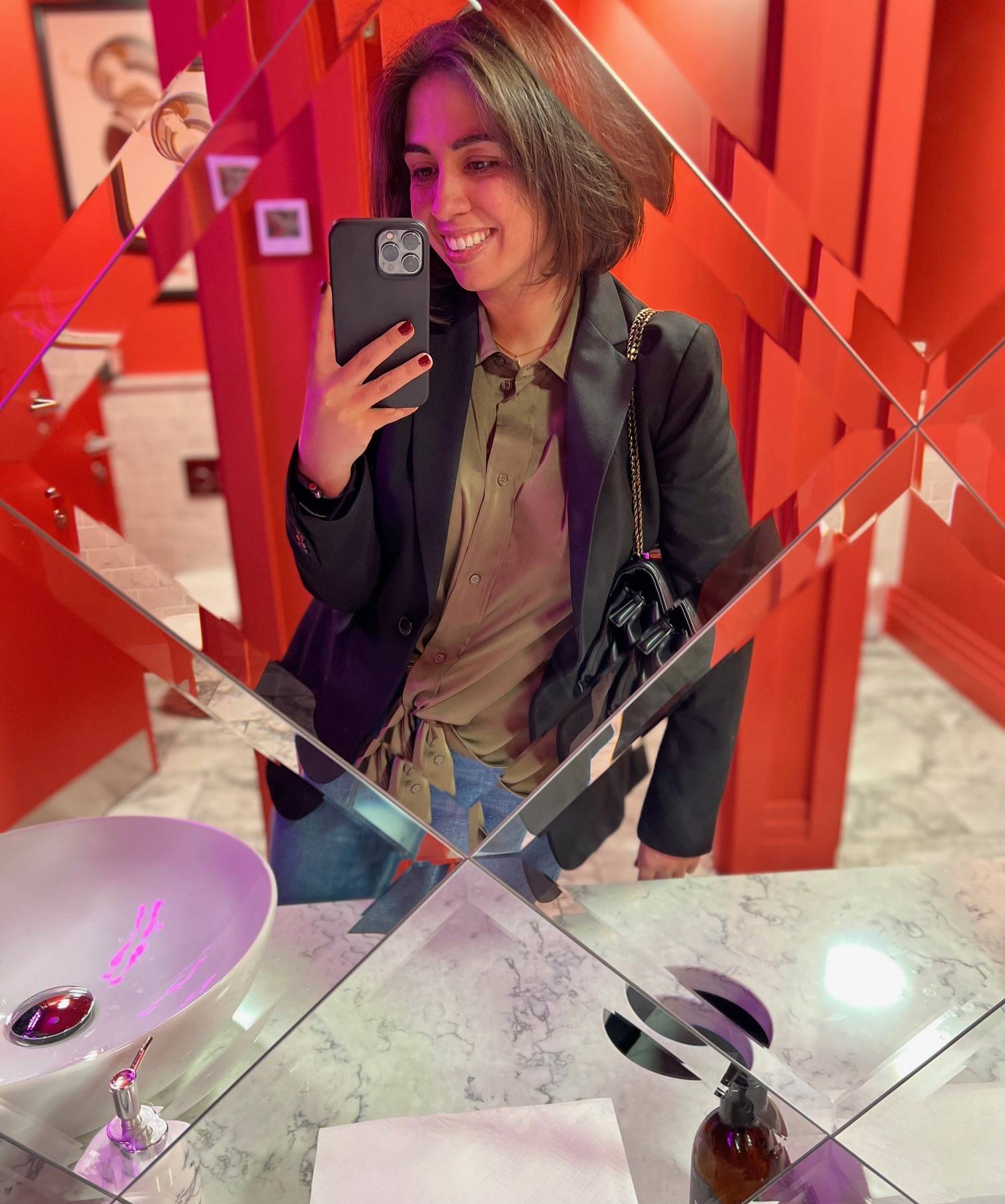 Woman holding a phone talking a photo in a mirror