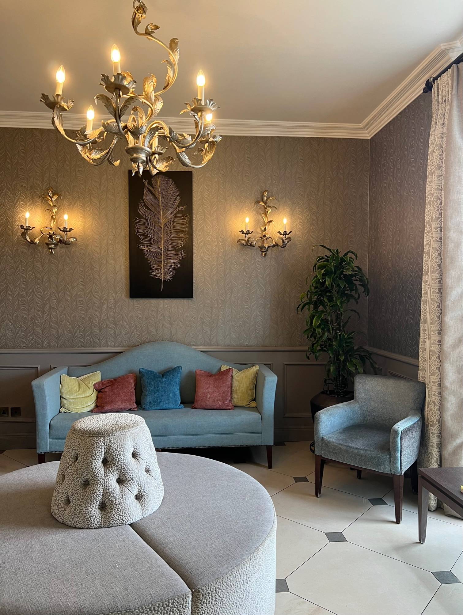 light blue sofa and armchair in hotel lobby with chandelier 