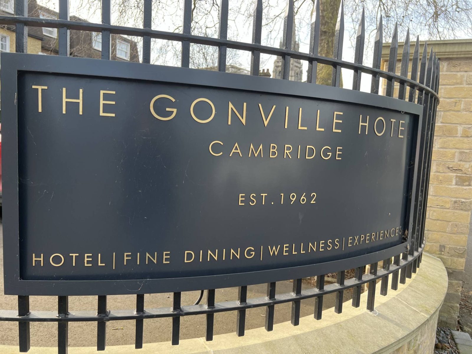 Outdoor hotel sign of The Gonville Cambridge - gold letting on black