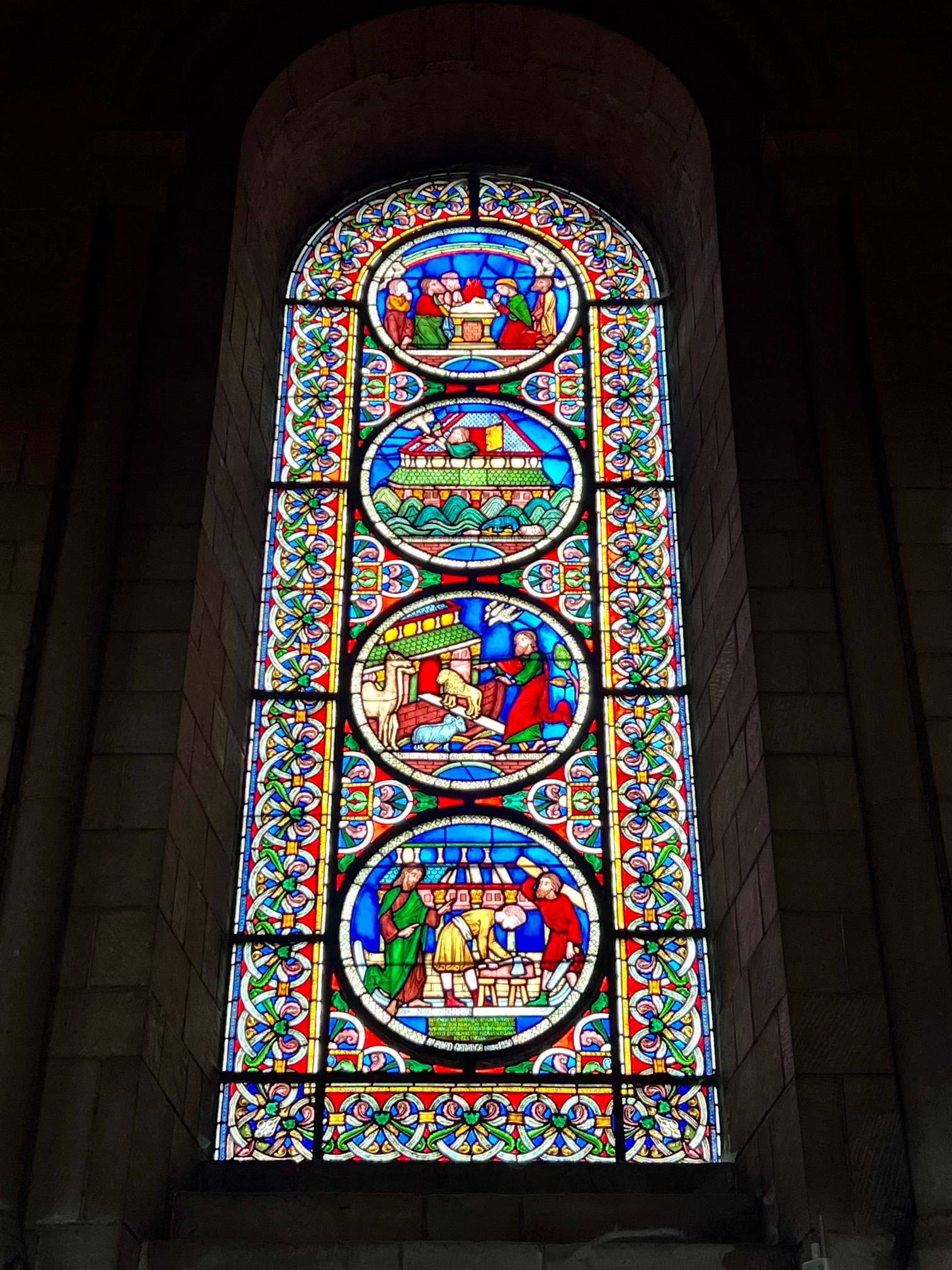 colourful stained glass window depicting Noah's Ark