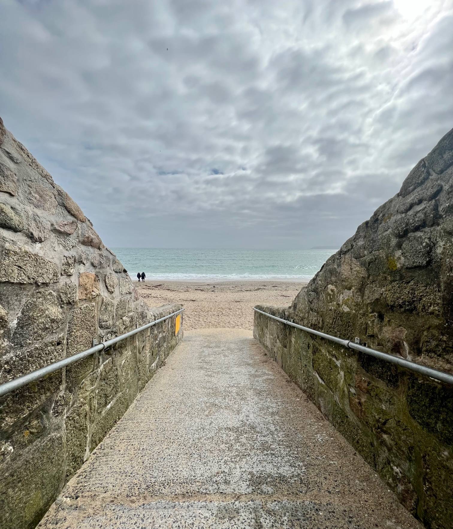 view of beach from stone walkway