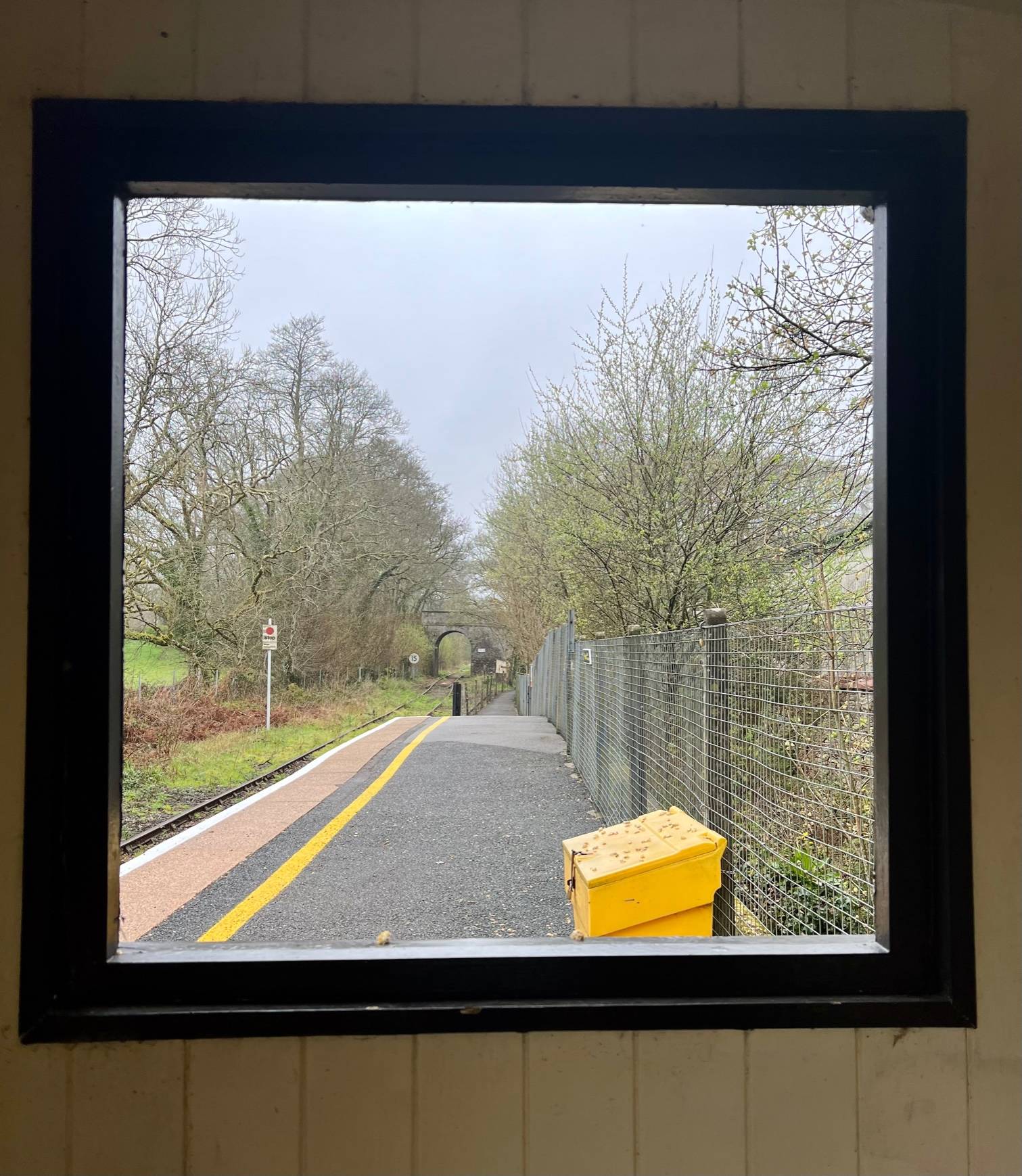 open window looking out to train platform and tracks beyond 